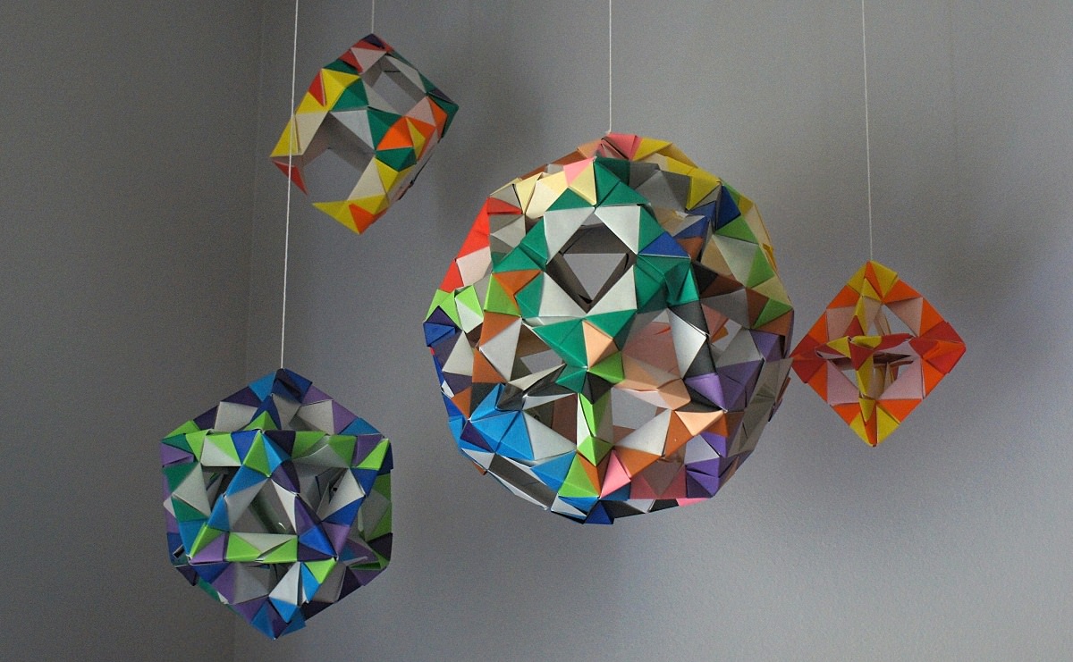 اوریگامی های مکعب و توپ که از سقف اتاق آویزان شده اند